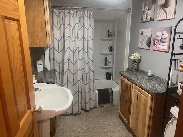 bathroom with shower / bathtub combination with curtain and a sink