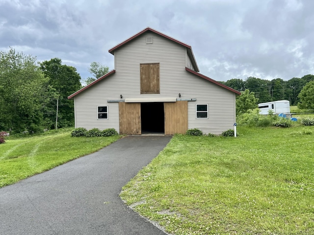 view of front facade featuring a barn, an outdoor structure, a front lawn, and a detached garage