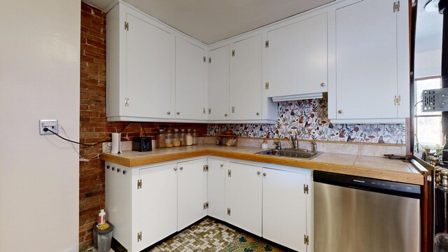 kitchen featuring light countertops, white cabinets, a sink, and dishwasher