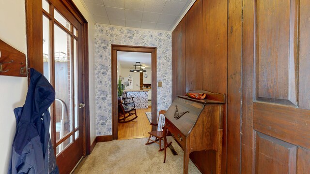 hallway featuring carpet flooring, wallpapered walls, and baseboards