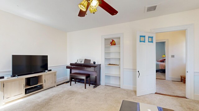 living area with carpet floors, ceiling fan, baseboards, and visible vents