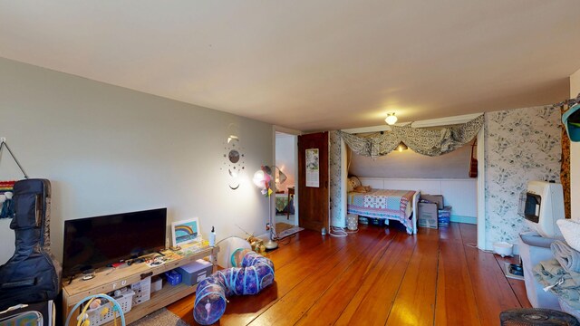 bedroom featuring heating unit and hardwood / wood-style floors