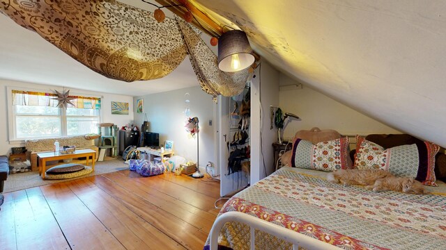 bedroom with vaulted ceiling and hardwood / wood-style floors