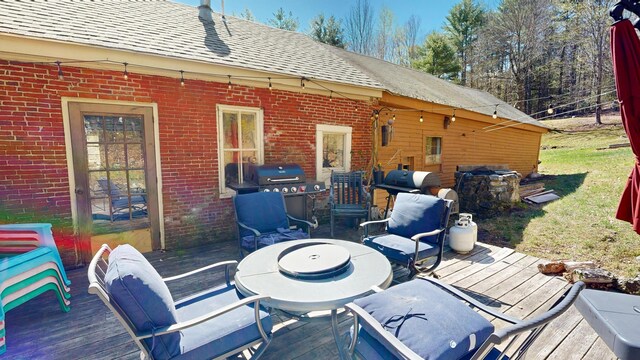 wooden terrace featuring outdoor dining area and grilling area