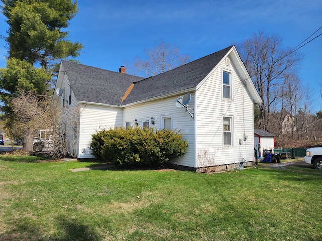 view of property exterior with a yard, a chimney, and a shingled roof