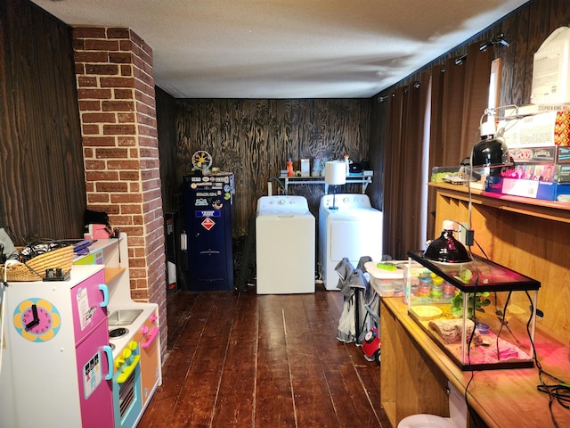 interior space featuring laundry area, wood walls, washer and dryer, and hardwood / wood-style flooring