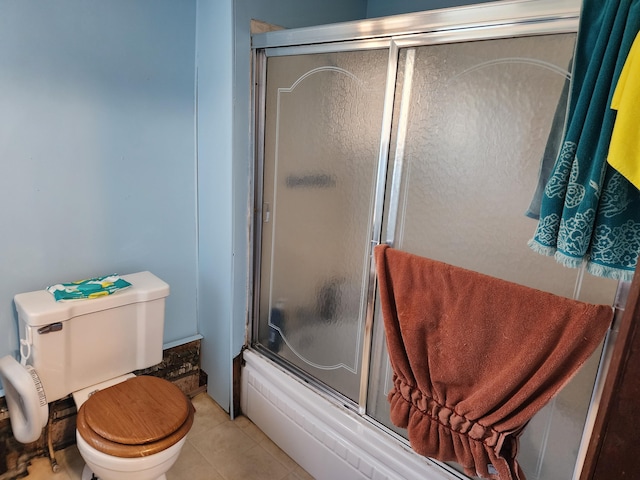 bathroom featuring tile patterned floors, enclosed tub / shower combo, and toilet
