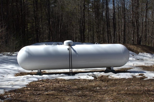 exterior details featuring heating fuel and a forest view