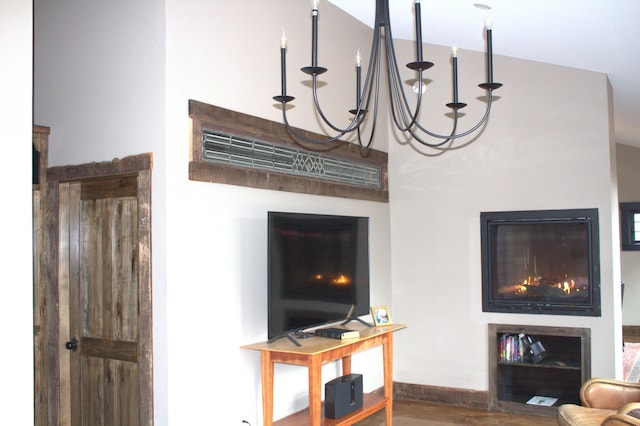 living area featuring baseboards, wood finished floors, and a notable chandelier