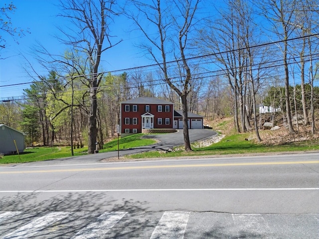 colonial home with driveway and a front yard