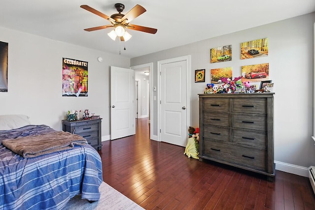bedroom featuring baseboard heating, baseboards, dark wood-style floors, and a ceiling fan