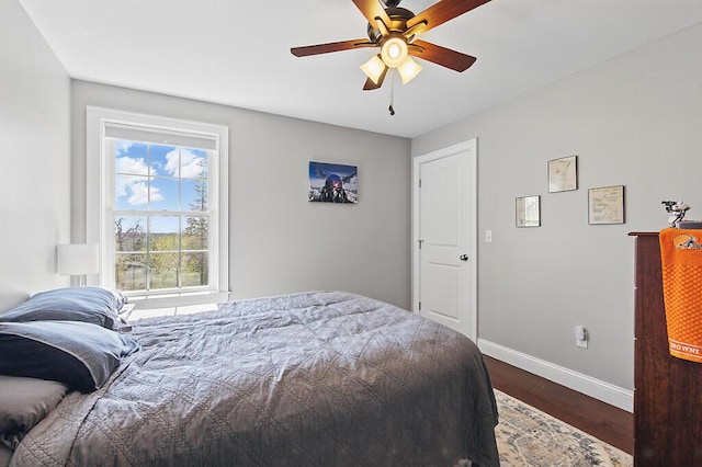 bedroom featuring dark wood-style flooring, baseboards, and ceiling fan