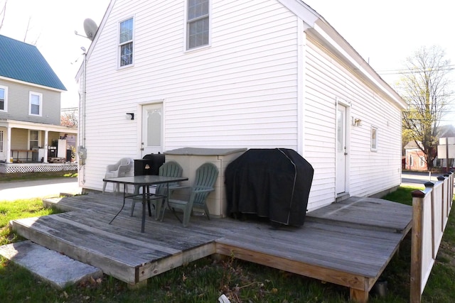 rear view of property featuring a deck and outdoor dining area