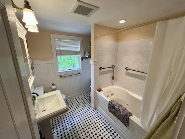 121 Jefferson St, Waldoboro, ME 04572 - bathroom featuring toilet, a wainscoted wall, a combined bath / shower with jetted tub, and a sink