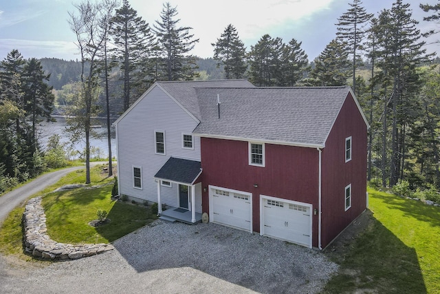 20 Campbell Rd, Southport, ME 04576 - view of front facade featuring a shingled roof, gravel driveway, a front lawn, and a garage