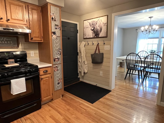 17 Fieldstone Dr, Bangor, ME 04401 - kitchen with black range with gas cooktop, under cabinet range hood, light wood-style flooring, and a chandelier