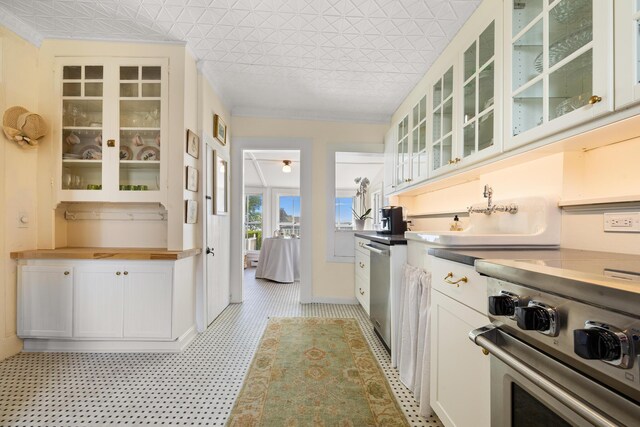 197A Perkins St, Castine, ME 04421 - kitchen with appliances with stainless steel finishes, glass insert cabinets, white cabinets, and wood counters