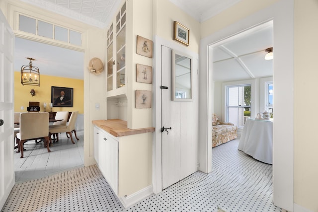 197A Perkins St, Castine, ME 04421 - hallway featuring light flooring, a chandelier, and ornamental molding