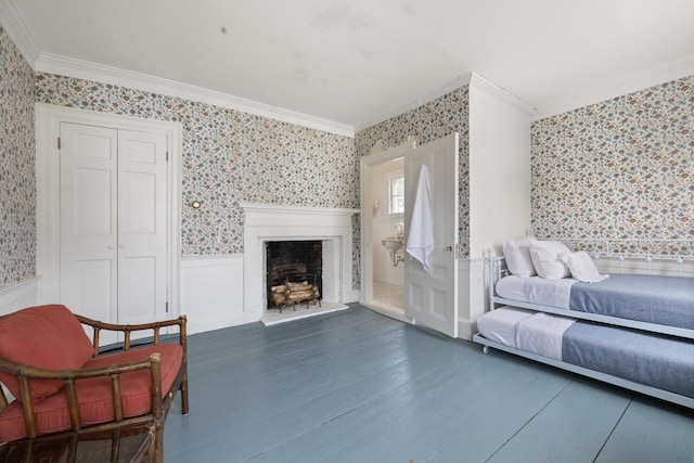 197A Perkins St, Castine, ME 04421 - living area featuring wallpapered walls, crown molding, a fireplace with raised hearth, a wainscoted wall, and wood finished floors