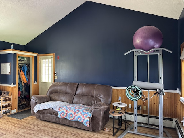 365 Snakeroot Rd, Pittsfield, ME 04967 - living room with wooden walls, a baseboard heating unit, wainscoting, and wood finished floors