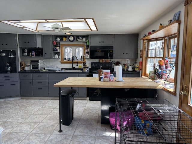 365 Snakeroot Rd, Pittsfield, ME 04967 - kitchen featuring open shelves, gray cabinets, black appliances, and tasteful backsplash