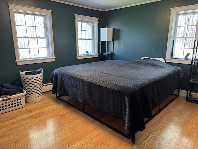 365 Snakeroot Rd, Pittsfield, ME 04967 - bedroom featuring crown molding, a baseboard radiator, and wood finished floors