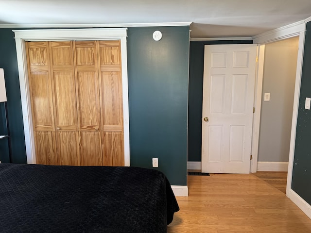 365 Snakeroot Rd, Pittsfield, ME 04967 - bedroom with light wood-style floors, baseboards, crown molding, and a closet