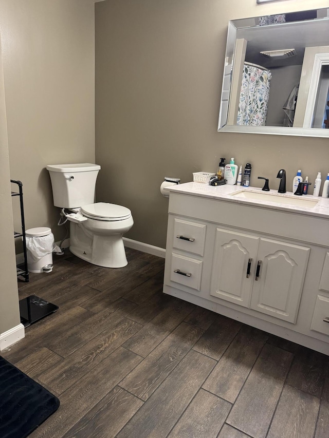 365 Snakeroot Rd, Pittsfield, ME 04967 - full bathroom with wood finished floors, vanity, baseboards, toilet, and a shower with shower curtain