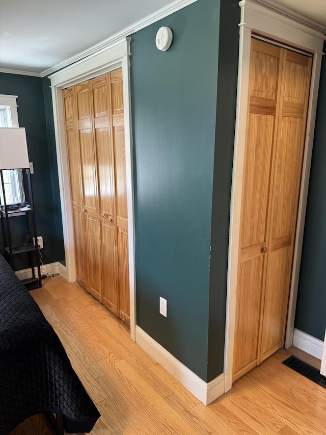 365 Snakeroot Rd, Pittsfield, ME 04967 - bedroom with crown molding, visible vents, a closet, baseboards, and light wood-type flooring
