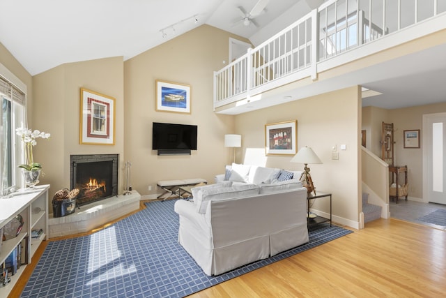 53 Jameson Point Rd Unit 24, Rockland, ME 04841 - living area featuring a warm lit fireplace, baseboards, ceiling fan, track lighting, and wood finished floors