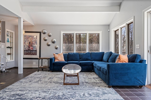 living area with dark tile patterned flooring and lofted ceiling with beams