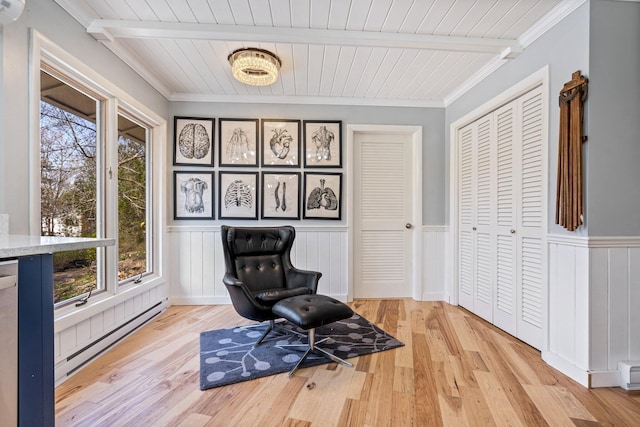 sitting room featuring wooden ceiling, a baseboard radiator, a wainscoted wall, and light wood-style flooring