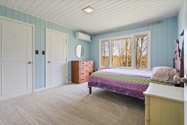 carpeted bedroom with an AC wall unit and wood ceiling