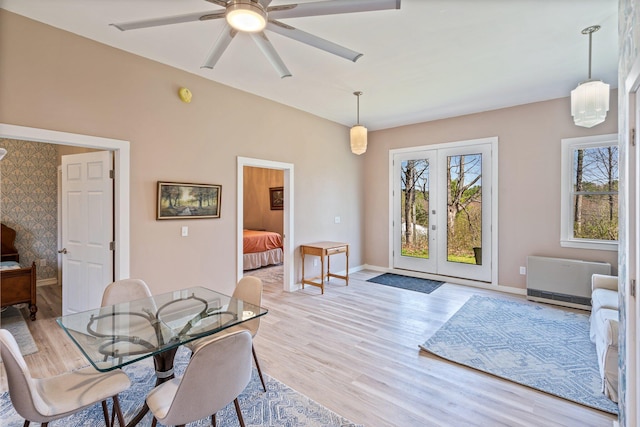 dining space with light wood-style floors, baseboards, ceiling fan, and french doors