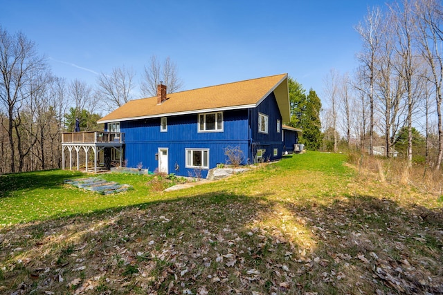 back of house with a lawn, a chimney, and a deck