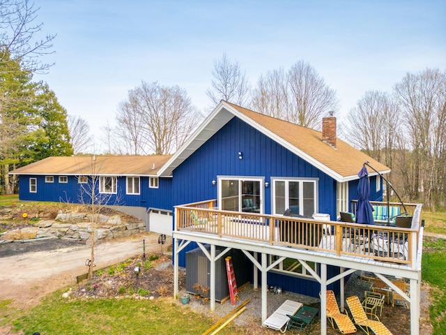 rear view of house featuring a wooden deck and a chimney