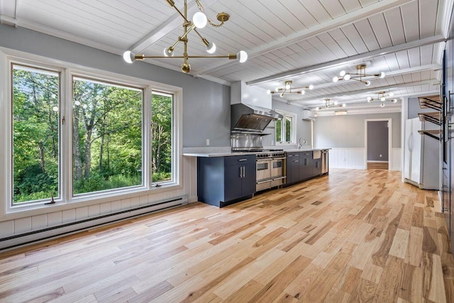 314 Meadow Rd, Topsham, ME 04086 - kitchen featuring a chandelier, range with two ovens, wall chimney range hood, light countertops, and a baseboard heating unit