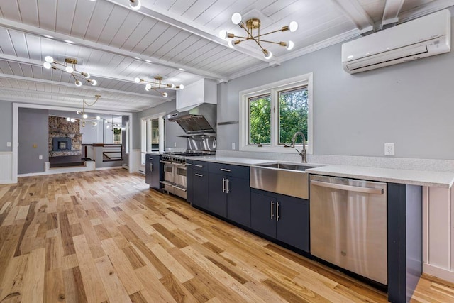 314 Meadow Rd, Topsham, ME 04086 - kitchen featuring appliances with stainless steel finishes, a wall unit AC, a chandelier, blue cabinets, and light wood finished floors