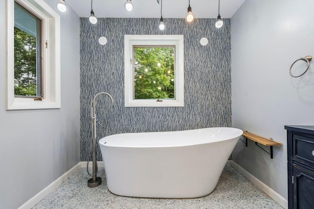 314 Meadow Rd, Topsham, ME 04086 - bathroom featuring a freestanding bath, speckle patterned floor, and an accent wall