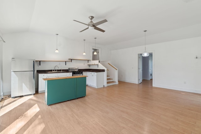 kitchen with a sink, a kitchen island, vaulted ceiling, and stainless steel appliances