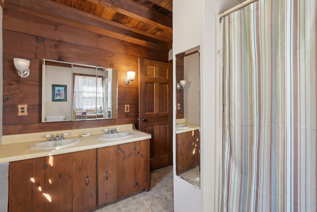 bathroom with double vanity, beam ceiling, wooden ceiling, and a sink