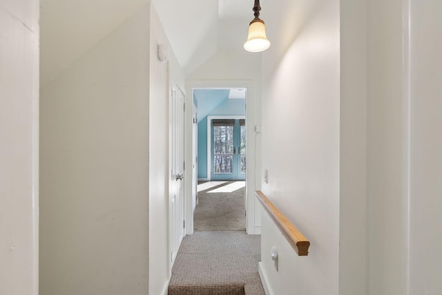 corridor featuring carpet flooring and vaulted ceiling