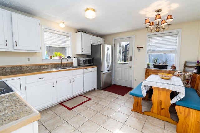kitchen featuring a sink, plenty of natural light, stainless steel appliances, and a chandelier