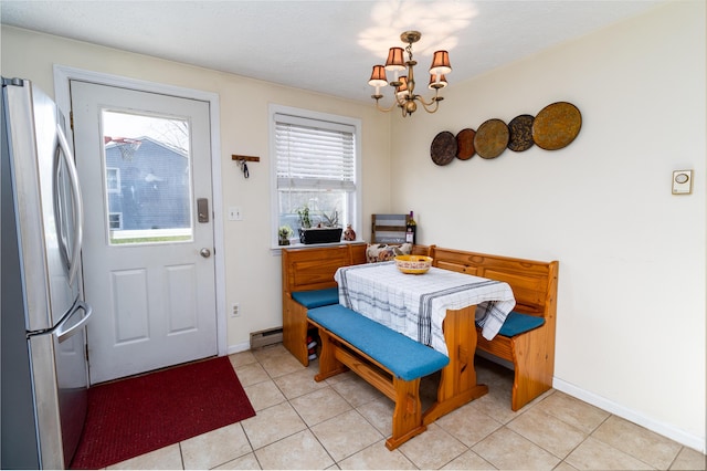 dining area featuring baseboards, a baseboard radiator, light tile patterned floors, and a chandelier