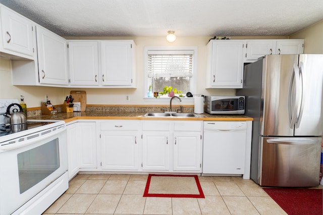 kitchen with a sink, appliances with stainless steel finishes, and white cabinetry