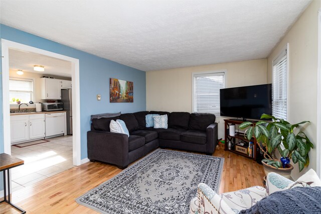 living area featuring light wood-style floors and a textured ceiling