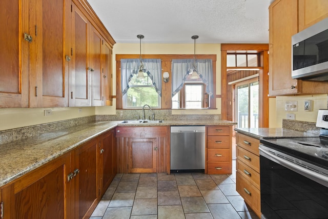 175 Summer St, Auburn, ME 04210 - kitchen with stainless steel appliances, pendant lighting, brown cabinetry, a textured ceiling, and light stone countertops