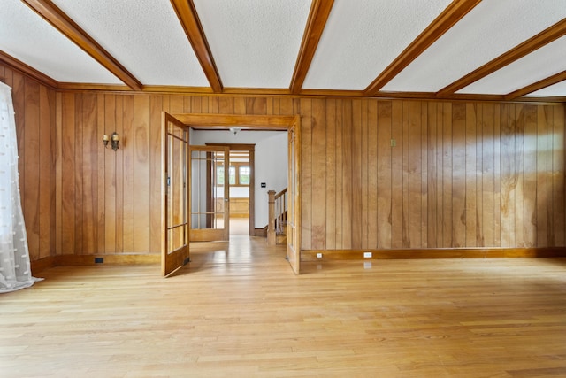 175 Summer St, Auburn, ME 04210 - empty room with beamed ceiling, wooden walls, wood finished floors, a textured ceiling, and stairs
