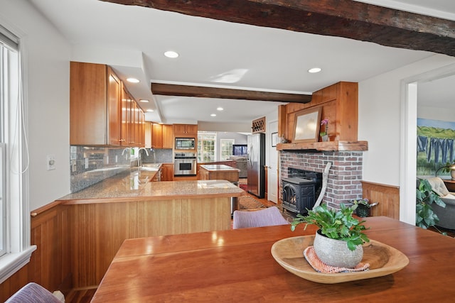 3 The Ledges St, Hallowell, ME 04347 - kitchen with appliances with stainless steel finishes, wainscoting, brown cabinets, beam ceiling, and a peninsula