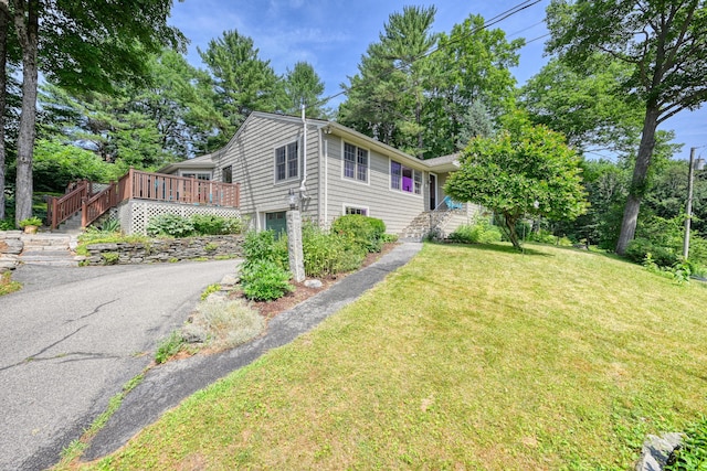 3 The Ledges St, Hallowell, ME 04347 - view of side of home featuring stairway, a yard, an attached garage, asphalt driveway, and a deck